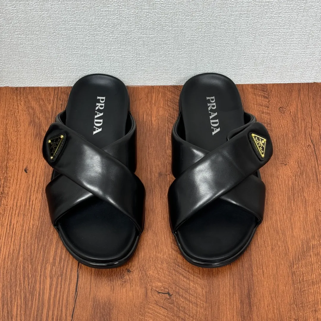 Batch 580 Prada/Prada's new men's leather cross slippers. Velcro closure can finely adjust the size. Calf leather light luxury slippers. Thick soft calf leather wraps the upper. Fat but soft rubber lazy style, soft and comfortable, excellent foot feel. Genuine leather bottom layer, cross style, with a Velcro closure buckle, easy to adjust the appropriate size, and a perfect fit for the wearing experience. The enamel gold triangle logo highlights the brand's classic features. Lightweight rubber thin sole, high foot comfort! Complete package! Size: 39-40-41-42-43-44-45 Leather shoe size Item number: 2X7132 Black